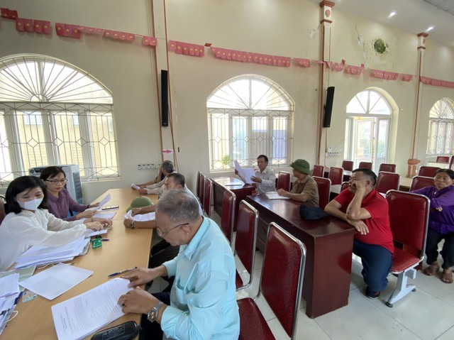 Cán bộ Trung tâm Phát triển quỹ đất huyện chi trả kinh phí bồi thường, hỗ trợ giải phóng mặt dự dự án đường Vành đai 4 cho người dân xã Đại Thịnh. Ảnh: Cổng thông tin điện tử huyện Mê Linh.