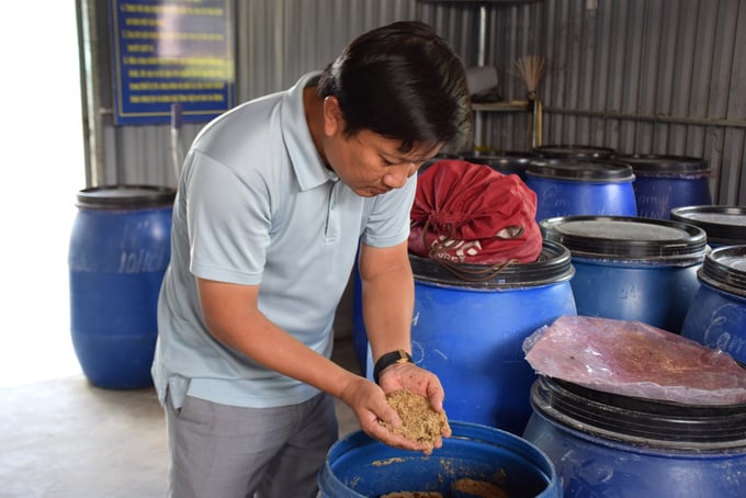 Anh Ca kiểm tra thức ăn được ủ trong những chiếc thùng nhựa. Ảnh: V.Đ.T.