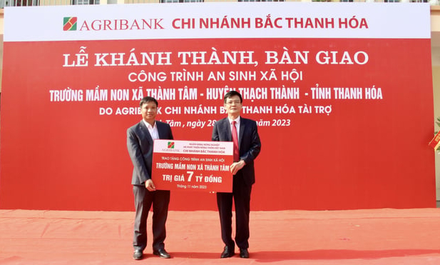 Ông Nguyễn Thái Triệu - Giám đốc Agribank Bắc Thanh Hóa trao tặng biểu trưng công trình an sinh xã hội Trường Mầm non xã Thành Tâm trị giá 7 tỷ đồng cho lãnh đạo xã Thành Tâm (Thạch Thành). Ảnh: Nguyễn Trường.