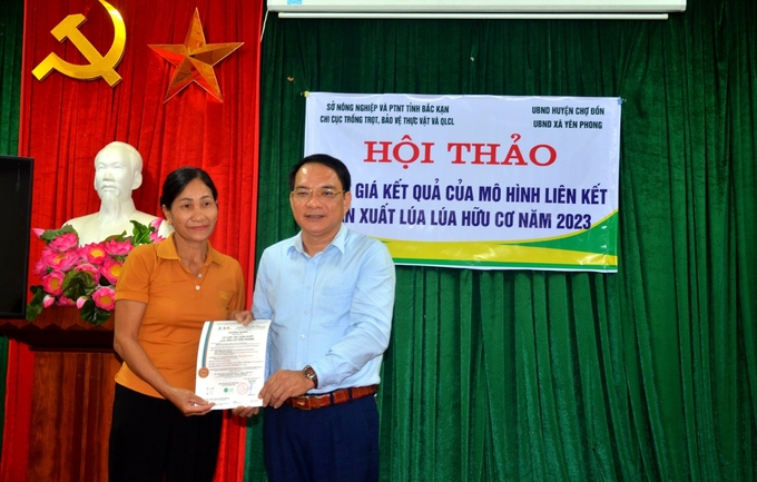 Ông Nguyễn Hoàng Tùng - Chi cục trưởng Chi cục Trồng trọt - BVTV và Quản lý chất lượng tỉnh Bắc Kạn trao chứng nhận hữu cơ cho bà Hoàng Thị Hỷ - Tổ trưởng Tổ hợp tác sản xuất lúa hữu cơ Yên Phong (huyện Chợ Đồn). Ảnh: Tư liệu.