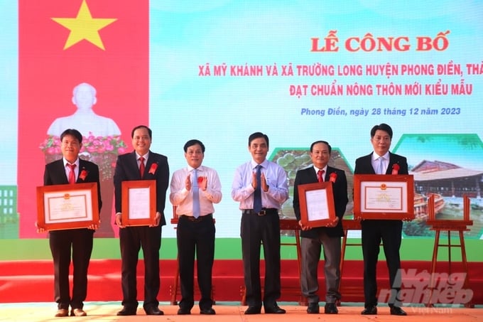 phong-dien-ra-mat-xa-nong-thon-moi-kieu-mau-dau-tien-164529_232-164529.jpg Ông Nguyễn Ngọc Hè, Phó Chủ tịch UBND TP Cần Thơ trao Quyết định công nhận xã đạt chuẩn nông thôn mới kiểu mẫu cho lãnh đạo 2 xã Mỹ Khánh và Trường Long của huyện Phong Điền. Ảnh: Kim Anh.