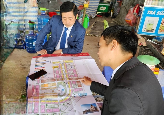 Hai môi giới chào mời mua ăn hộ tại Dự án khu đô thị Kim Phú, dù việc này là vi phạm pháp luật. Ảnh: Văn Việt.