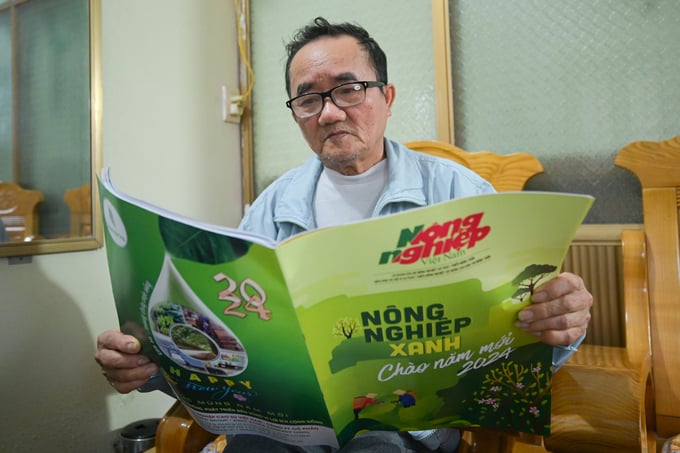 Ông Thưởng xem số đặc biệt chào năm mới 2024 của Báo Nông nghiệp Việt Nam. Ảnh: Tùng Đinh.