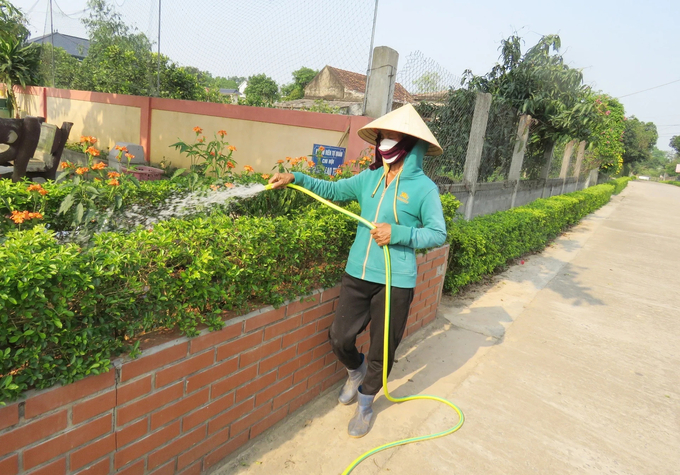 Các Chi hội Phụ nữ tham gia chăm sóc cây cảnh trên các tuyến đường. Ảnh: T. Đức.