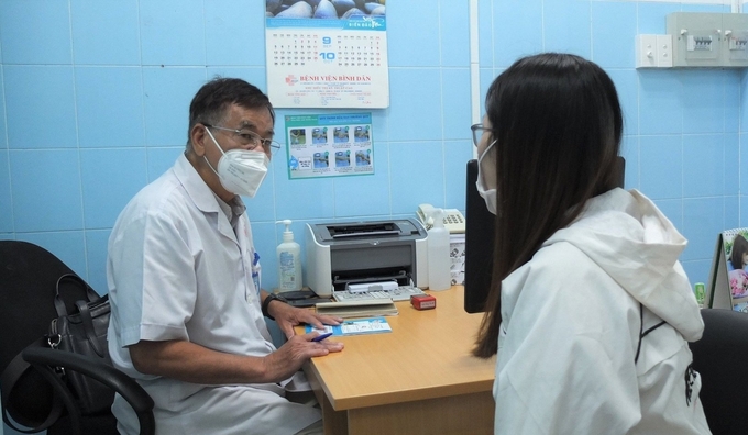 PGS.TS.BS Dương Văn Hải, Trưởng đơn vị Hậu môn Trực tràng, Bệnh viện Bình Dân thăm khám cho bệnh nhân. Ảnh: T.Nhung.