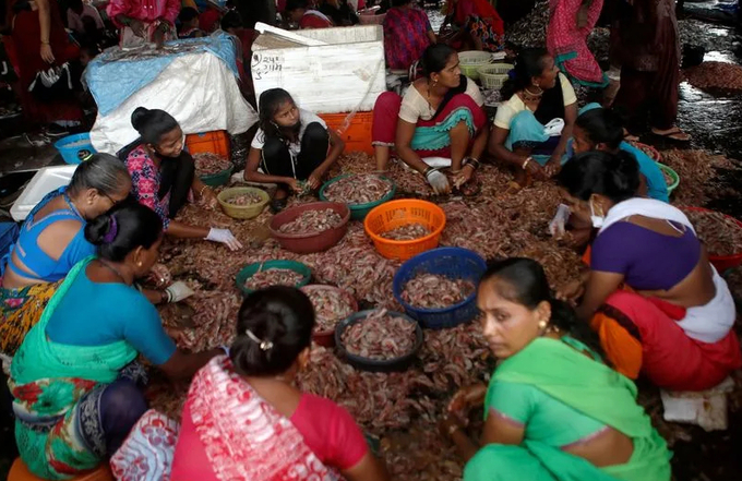 Women clean prawns at a fish market amidst the spread of the coronavirus disease (COVID-19), in Mumbai.