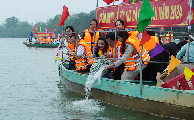 Thả cá giống đầu nguồn sông Kiến Giang trong Lễ hội đầu Xuân của huyện Lệ Thủy. Ảnh: T. Phùng.