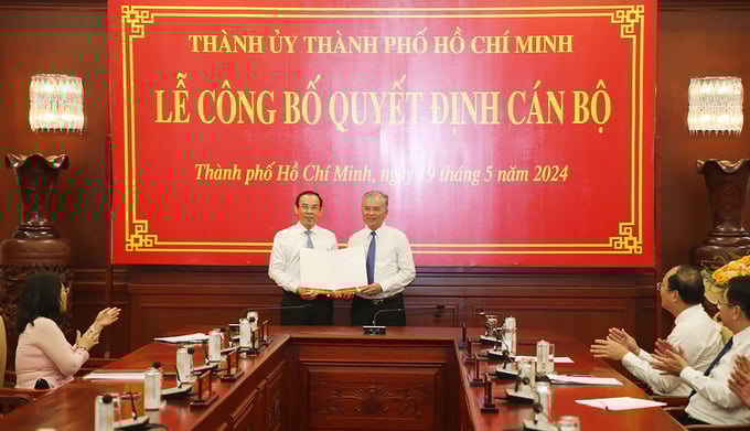 hai-pho-chu-tich-ubnd-tphcm-nhan-nhiem-vu-moi-141030_586.jpg Bí thư Thành ủy TP.HCM Nguyễn Văn Nên trao quyết định phân công nhiệm vụ cho ông Ngô Minh Châu. Ảnh: L.H.