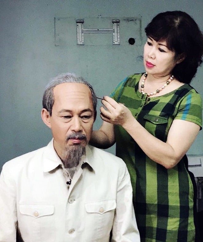 z5445190042362_2f0a60e3f36c47deb771ca6f61c7ce2f-103830_420.jpg Chị Đạm Thủy đang hóa trang cho chồng là nghệ sĩ Tiến Hợi để đóng vai Bác Hồ. Ảnh: Tư liệu gia đình.