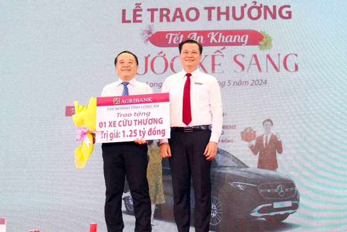 tang-xe-cuu-thuong-va-trao-thuong-chuong-trinh-tet-an-khang--ruoc-xe-sang-093832_185.jpg Ông Nguyễn Trí Dũng, Phó Giám đốc phụ trách điều hành Agribank Long An trao bảng tượng trưng tặng xe cứu thương cho ông Huỳnh Minh Phúc, Giám đốc Sở Y tế tỉnh Long An. Ảnh: Minh Khương.