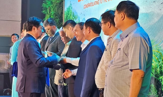 Minister Le Minh Hoan presenting National Park Passports to delegates at the ceremony. Photo: Bao Thang.