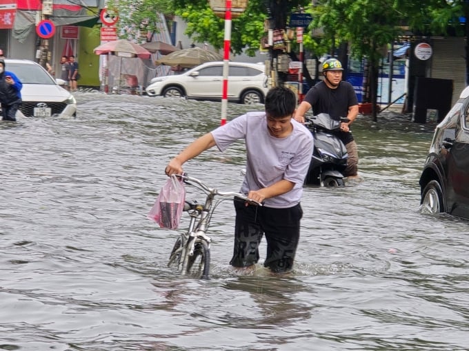 People miserable wading on the street after the rain. Photo: Hoang Muoi.