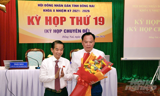Chủ tịch HĐND tỉnh Đồng Nai Thái Bảo tặng hoa chúc mừng Chủ tịch UBND tỉnh Võ Tấn Đức. Ảnh: Hoàng Phúc. 