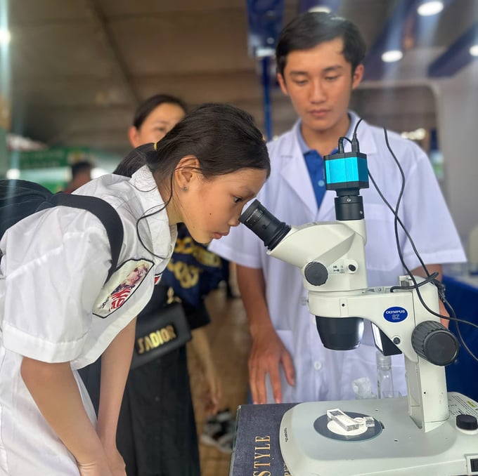 z5786984893077_ecb484f8891c7f25af2bb5c58f3133a7-173617_441.jpg Nhân viên Corteva hướng dẫn du khách soi mẫu vật qua kính hiển vi tại giang hàng hội chợ. Ảnh: Quang Yên.