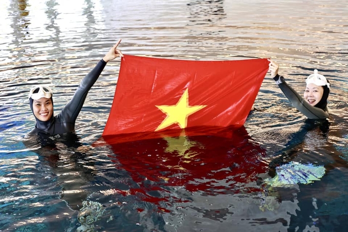 co-do-sao-vang-tung-bay-trong-be-boi-sau-nhat-the-gioi-ngay-quoc-khanh-viet-nam-2-9-235324_215.jpg Ngọc Bích (trái) và Ngọc Bảo nâng cao Quốc kỳ Việt Nam mừng ngày Quốc khánh 2/9 trong bể bơi sâu nhất thế giới ở Dubai