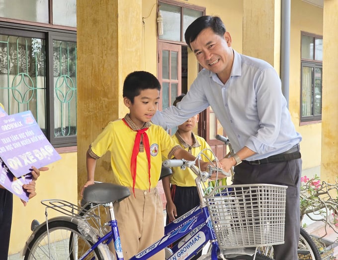 thap-ngon-lua-hy-vong-cho-hoc-sinh-ven-bien-hai-phong-nam-dinh-205239_501.jpg Ông Đặng Văn Thành, Giám đốc Công ty GrowMax khu vực miền Bắc trao xe đạp cho học sinh Trường Tiểu học Tân Trào. Ảnh: Đinh Mười.