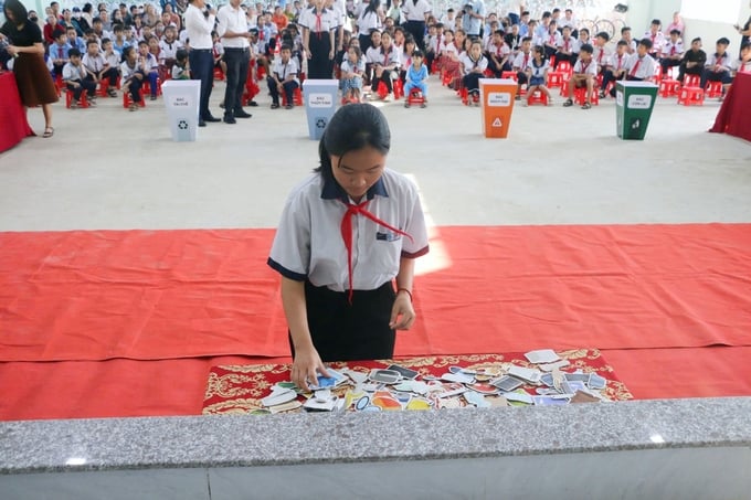 Học sinh các trường trong huyện Phú Vang được thực hành phân loại rác tại nguồn vào các nhóm khác nhau. Ảnh: Kiên Đồng.