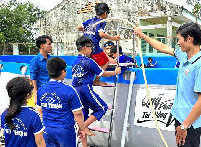 hoc-sinh-duoc-cac-thay-rua-chan-sach-truoc-khi-vao-hoc-boi-trong-ho-moi-123011_209.jpg Học sinh háo hức rửa chân để được học bơi trong chiếc hồ mới. Ảnh: Nutifood.