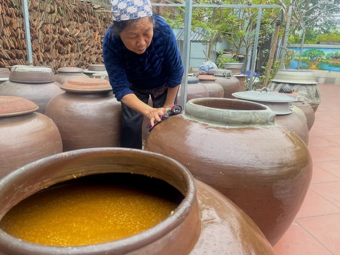 Bà Thức cẩn thận lau dọn những vết tương rớt trên chum sau khi xát hoặc bán tương. Ảnh: Minh Toàn.