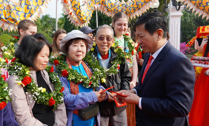 Đại diện Ban lãnh đạo Vườn Quốc gia Phong Nha - Kẻ Bàng tặng hoa, lì xì đầu năm mới cho các du khách quốc tế. Ảnh: C.T.V.