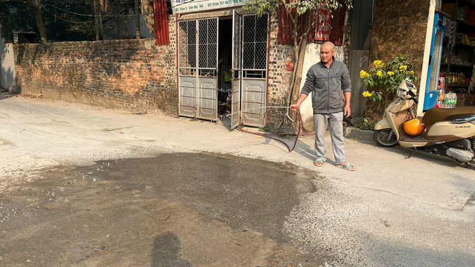 z6212553095061_104b12661b81ddd2da427a50c290c3e4-192558_404.jpg Người dân phải tưới rửa đường thường xuyên để ngăn bụi bẩn. Ảnh: Đức Minh.
