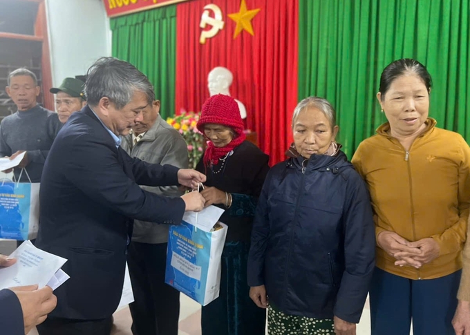 1-071030_404.jpg Ông Nguyễn Hữu Khúc, Phó Giám đốc Sở Kế hoạch và Đầu tư tỉnh Bình Định, trao quà Tết cho những hộ nghèo ở huyện miền núi An Lão. Ảnh: V.Đ.T.