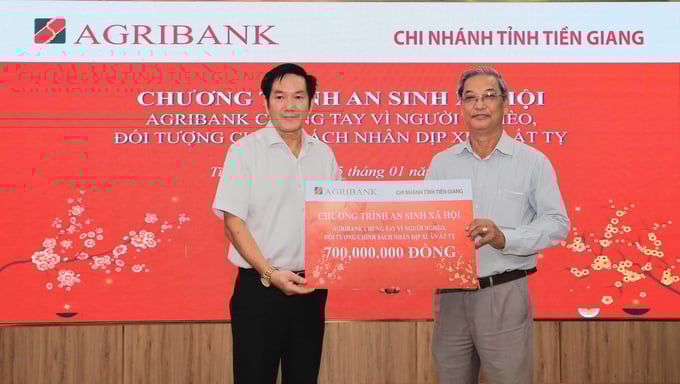 cac-chi-nhanh-agribank-khu-vuc-tay-nam-bo-don-tet-nghia-tinh-cung-ba-con-154410_593.jpg Ông Trương Văn Đoàn (bên trái) - Giám đốc Agribank chi nhánh tỉnh Tiền Giang hỗ trợ 700 triệu đồng cho chương trình an sinh xã hội của tỉnh. Ảnh: MK.