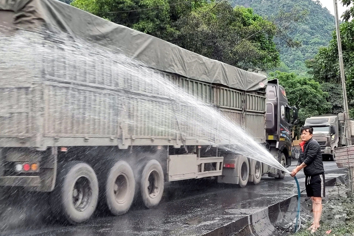 Bụi than khiến người dân sống cạnh quốc lộ 15D thường xuyên phải tưới nước. Ảnh: Võ Dũng. Bụi than khiến người dân sống cạnh quốc lộ 15D thường xuyên phải tưới nước. Ảnh: Võ Dũng.