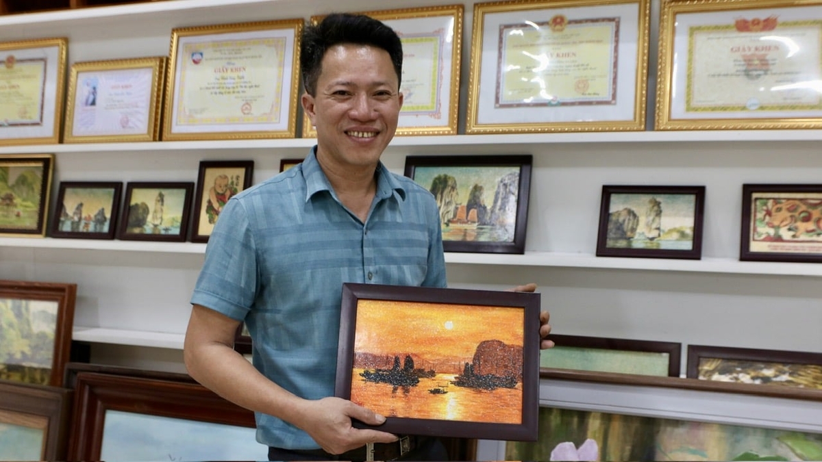 Anh Đinh Công Tuyến cùng tác phẩm tranh bột điệp về cảnh vịnh Hạ Long. Ảnh: Thanh Phương. Anh Đinh Công Tuyến cùng tác phẩm tranh bột điệp về cảnh vịnh Hạ Long. Ảnh: Thanh Phương.