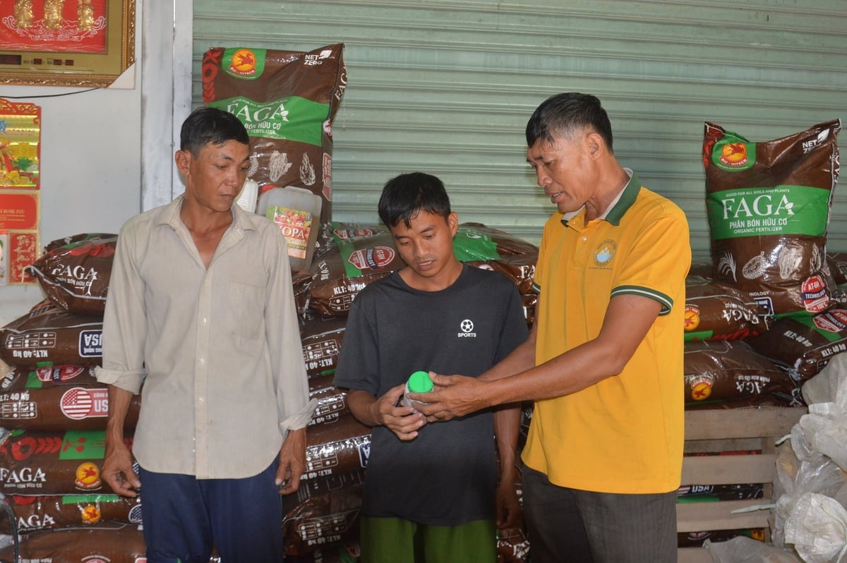 Anh Mười (bìa phải) chia sẻ về phân bón hữu cơ, thuốc bảo vệ thực vật sinh học cho nông dân nhằm lan tỏa mô hình sản xuất hữu cơ, sinh học trong canh tác lúa. Ảnh: Trung Chánh. 