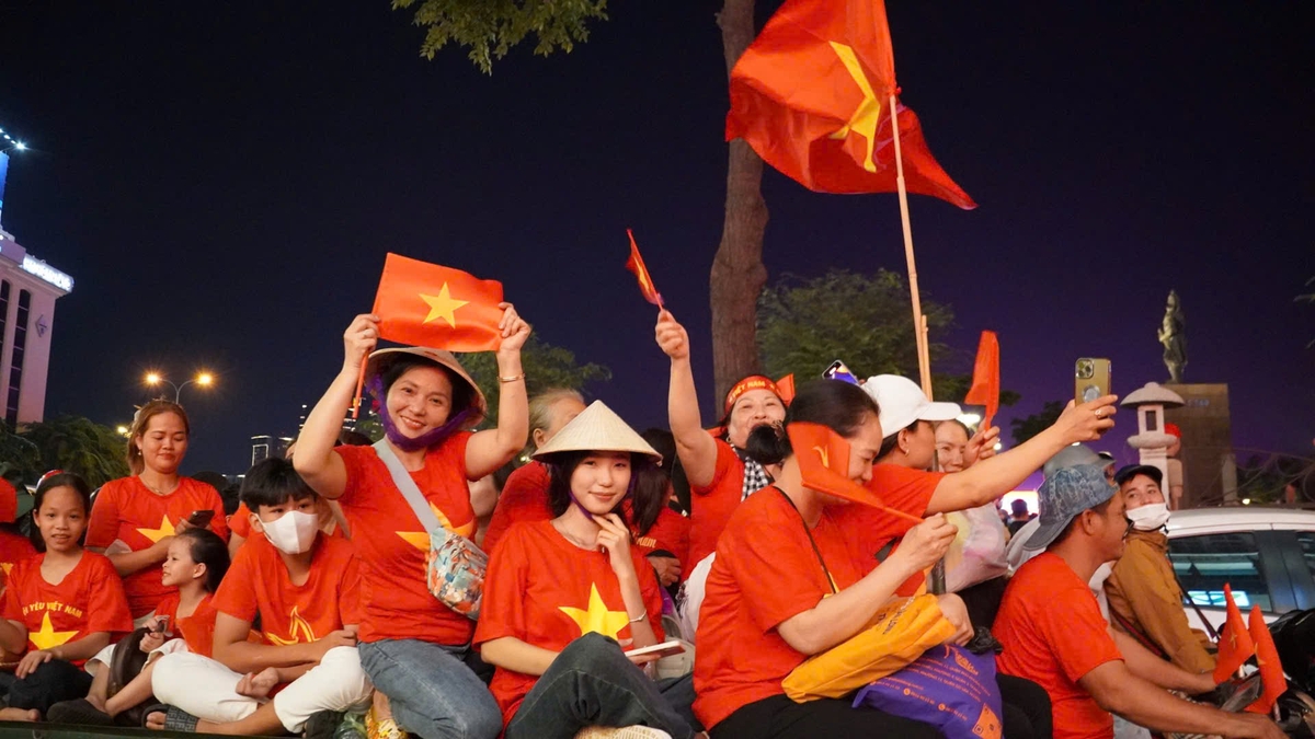 Người dân ngồi kín hai bên đường tại Bến Bạch Đăng, vẫy cờ, mặc áo đỏ, chờ xem màn diễu binh. Người dân ngồi kín hai bên đường tại Bến Bạch Đăng, vẫy cờ, mặc áo đỏ, chờ xem màn diễu binh.