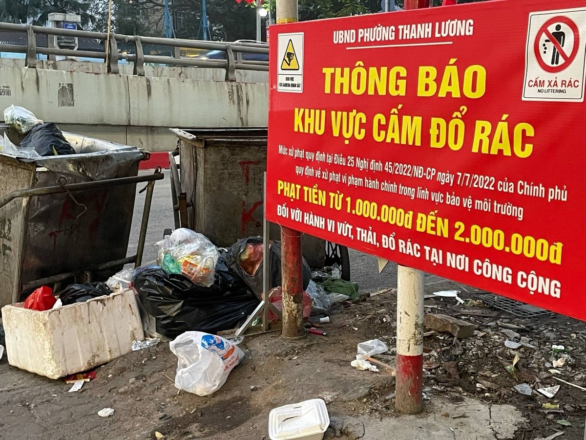 Vẫn hình ảnh quen thuộc: Có biển cấm và có xe thu gom nhưng rác vẫn không được vứt đúng chỗ. Ảnh: Hoàng Hiền.