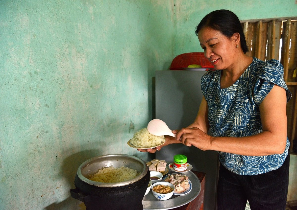 Vợ ông Đinh Văn Dự đồ xôi để đãi khách. Ảnh: Dương Đình Tường. Vợ ông Đinh Văn Dự đồ xôi để đãi khách. Ảnh: Dương Đình Tường.