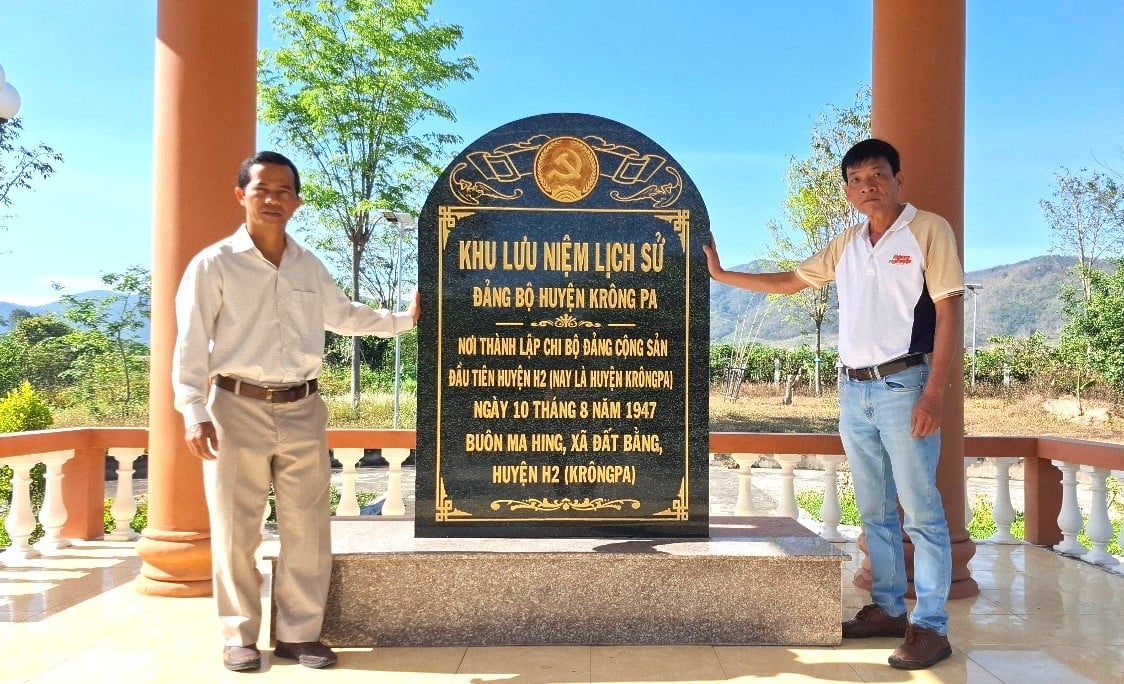 Anh Rô Krik (trái), Chủ tịch xã Đất Bằng bên Bia lưu niệm lịch sử Đảng bộ huyện Krông Pa. Ảnh: Tuấn Anh. Anh Rô Krik (trái), Chủ tịch xã Đất Bằng bên Bia lưu niệm lịch sử Đảng bộ huyện Krông Pa. Ảnh: Tuấn Anh.