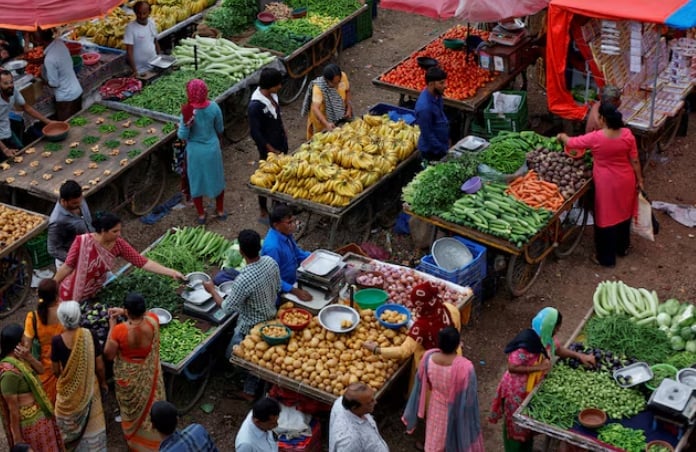 Customers buy fruits and vegetables at an open air evening market in Ahmedabad, India, August 21, 2023.