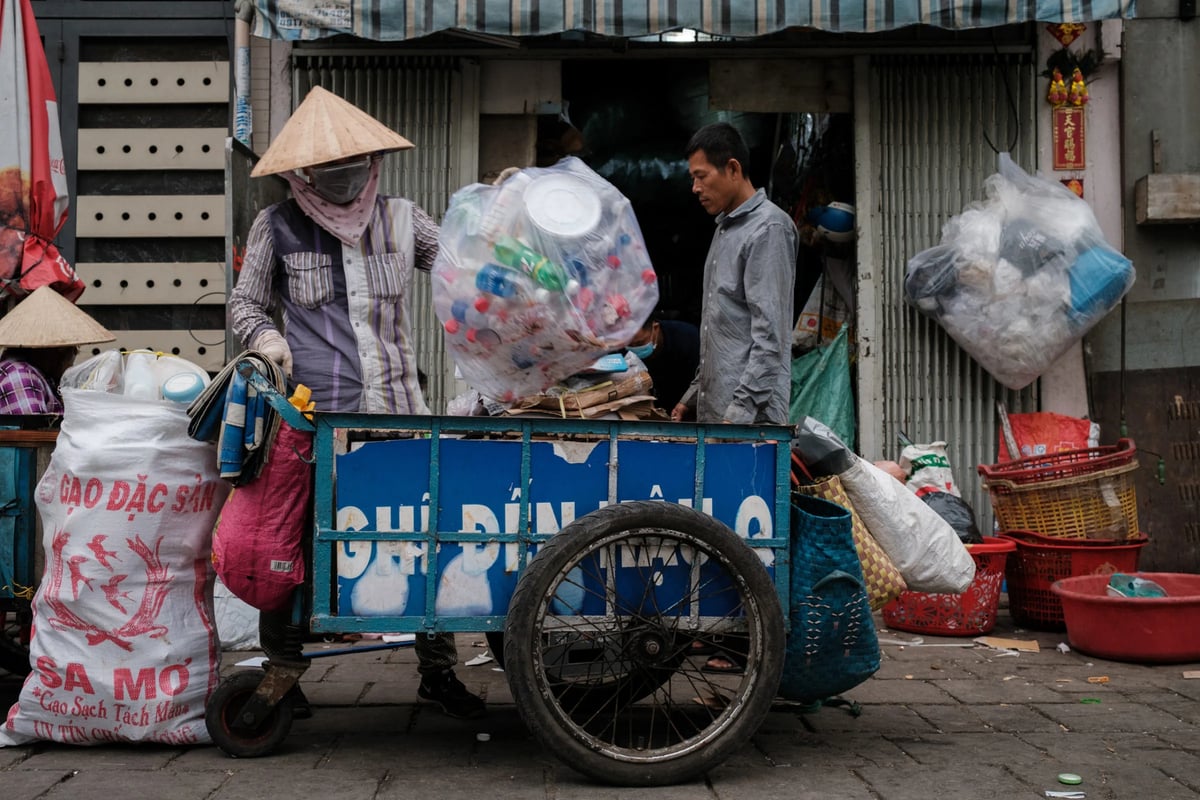 An informal waste worker piles recyclable plastic bottles onto her cart in southern Vietnam’s Ho Chi Minh City. Photo: Jack Ross.