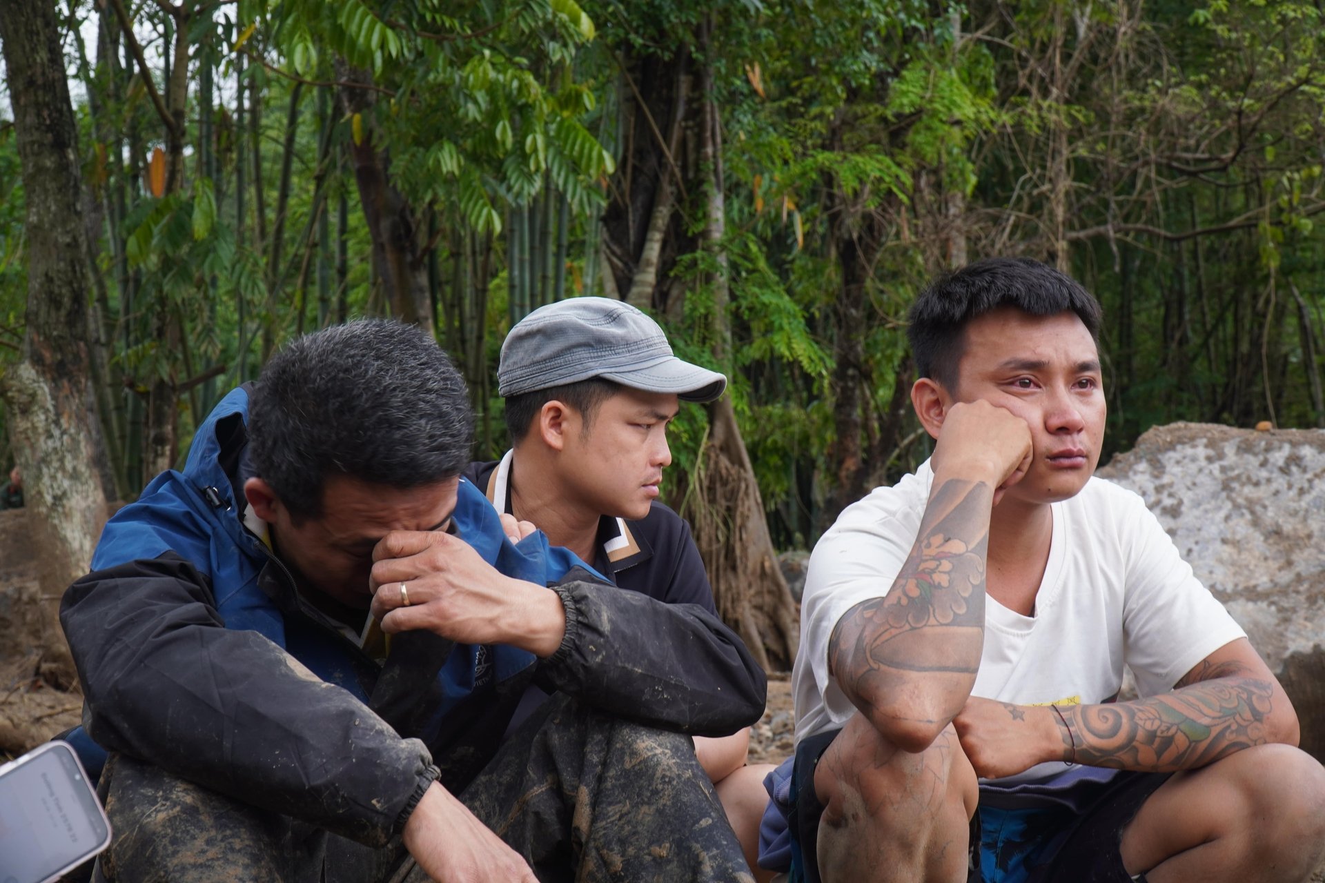 Anh Dương Hồng Phong (ngoài cùng bên phải), thất thần nhìn nhà cửa bị đất đá lấp hoàn toàn, bà của anh Phong tử vong trong trận lũ quét. Anh Dương Hồng Phong (ngoài cùng bên phải), thất thần nhìn nhà cửa bị đất đá lấp hoàn toàn, bà của anh Phong tử vong trong trận lũ quét.