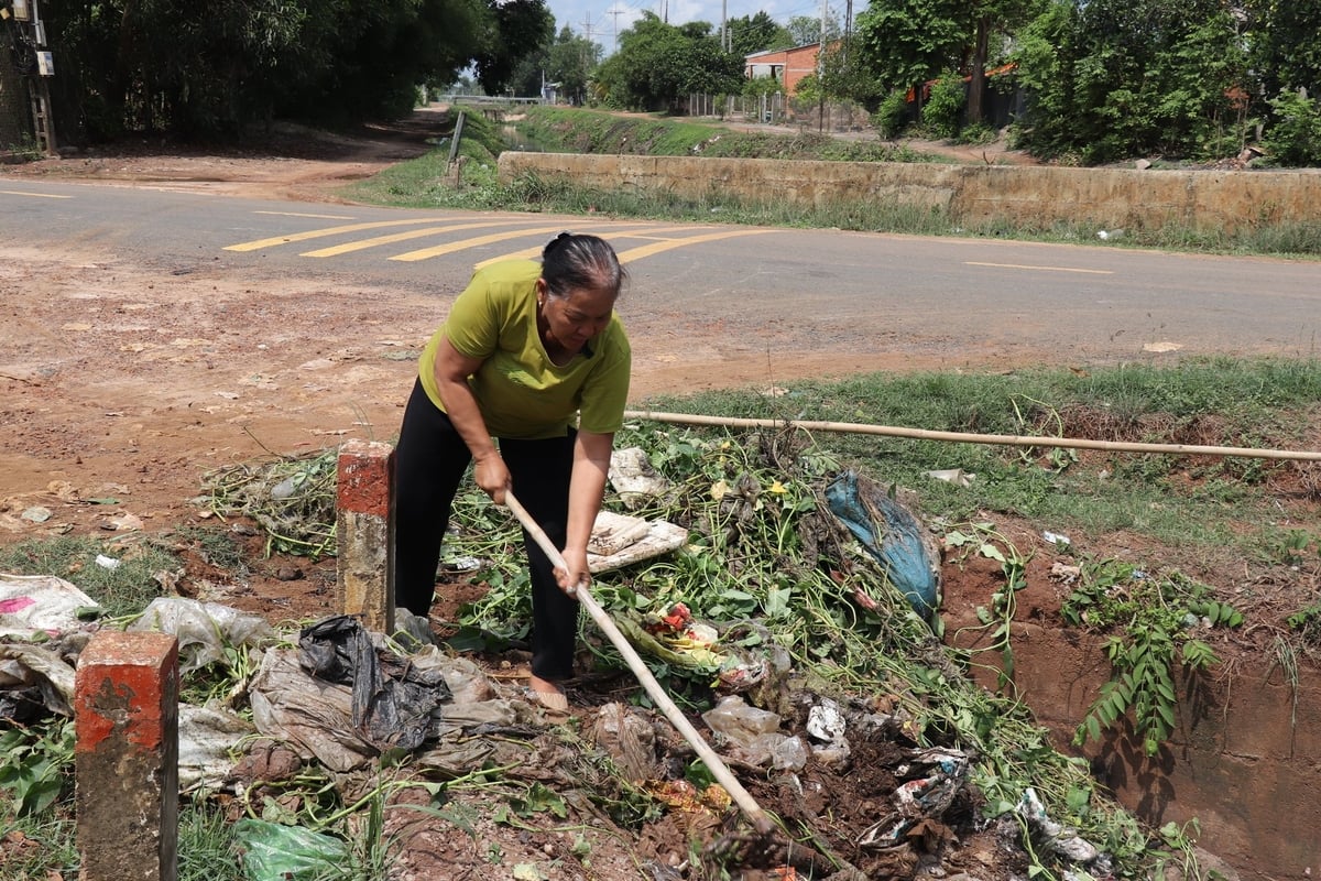 Bà Nguyễn Thị Kim Huyền chủ động vớt rác nhưng không cứu nổi dòng kênh thủy lợi. Ảnh: Trần Trung. Bà Nguyễn Thị Kim Huyền chủ động vớt rác nhưng không cứu nổi dòng kênh thủy lợi. Ảnh: Trần Trung.