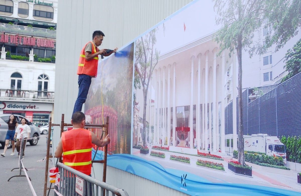 Các công nhân đang lập hàng rào tôn xung quanh tòa nhà. Ảnh: Xuân Hà.