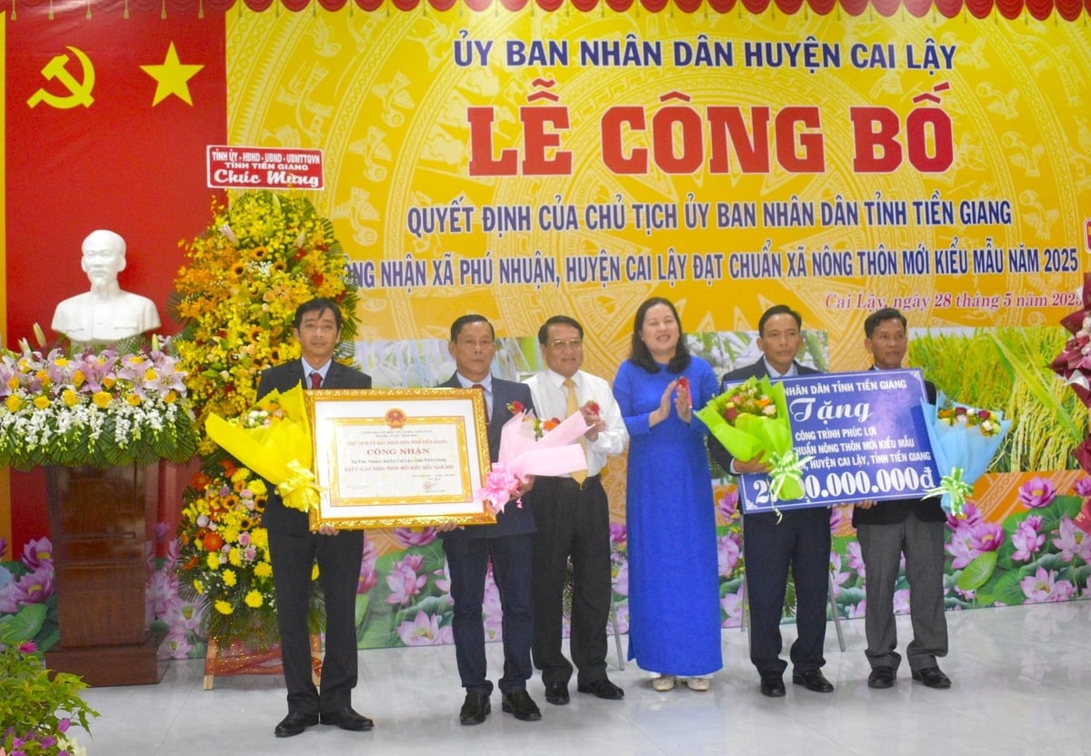 Dịp này, Phó Chủ tịch UBND tỉnh Tiền Giang Phạm Văn Trọng và Phó Giám đốc Sở Nông nghiệp và Môi trường Trần Thị Bé Bảy trao bằng công nhận và bảng tượng trưng tặng công trình phúc lợi trị giá 2 tỷ đồng của tỉnh Tiền Giang cho xã Phú Nhuận. Ảnh: Minh Đảm. Dịp này, Phó Chủ tịch UBND tỉnh Tiền Giang Phạm Văn Trọng và Phó Giám đốc Sở Nông nghiệp và Môi trường Trần Thị Bé Bảy trao bằng công nhận và bảng tượng trưng tặng công trình phúc lợi trị giá 2 tỷ đồng của tỉnh Tiền Giang cho xã Phú Nhuận. Ảnh: Minh Đảm.