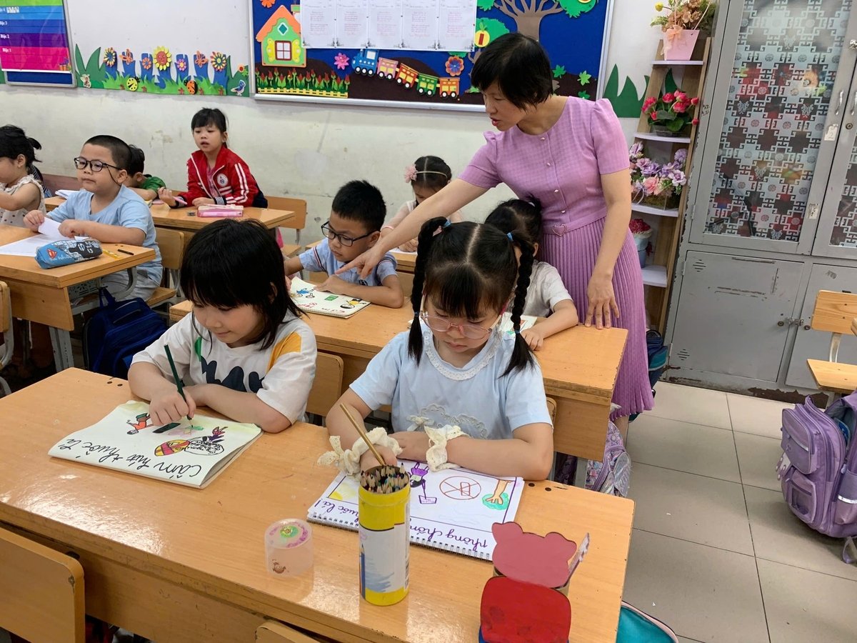 Cô giáo hướng dẫn các em học sinh Trường Tiểu học Ngô Quyền vẽ tranh phòng chống tác hại thuốc lá. Ảnh: Mai Anh. Cô giáo hướng dẫn các em học sinh Trường Tiểu học Ngô Quyền vẽ tranh phòng chống tác hại thuốc lá. Ảnh: Mai Anh.