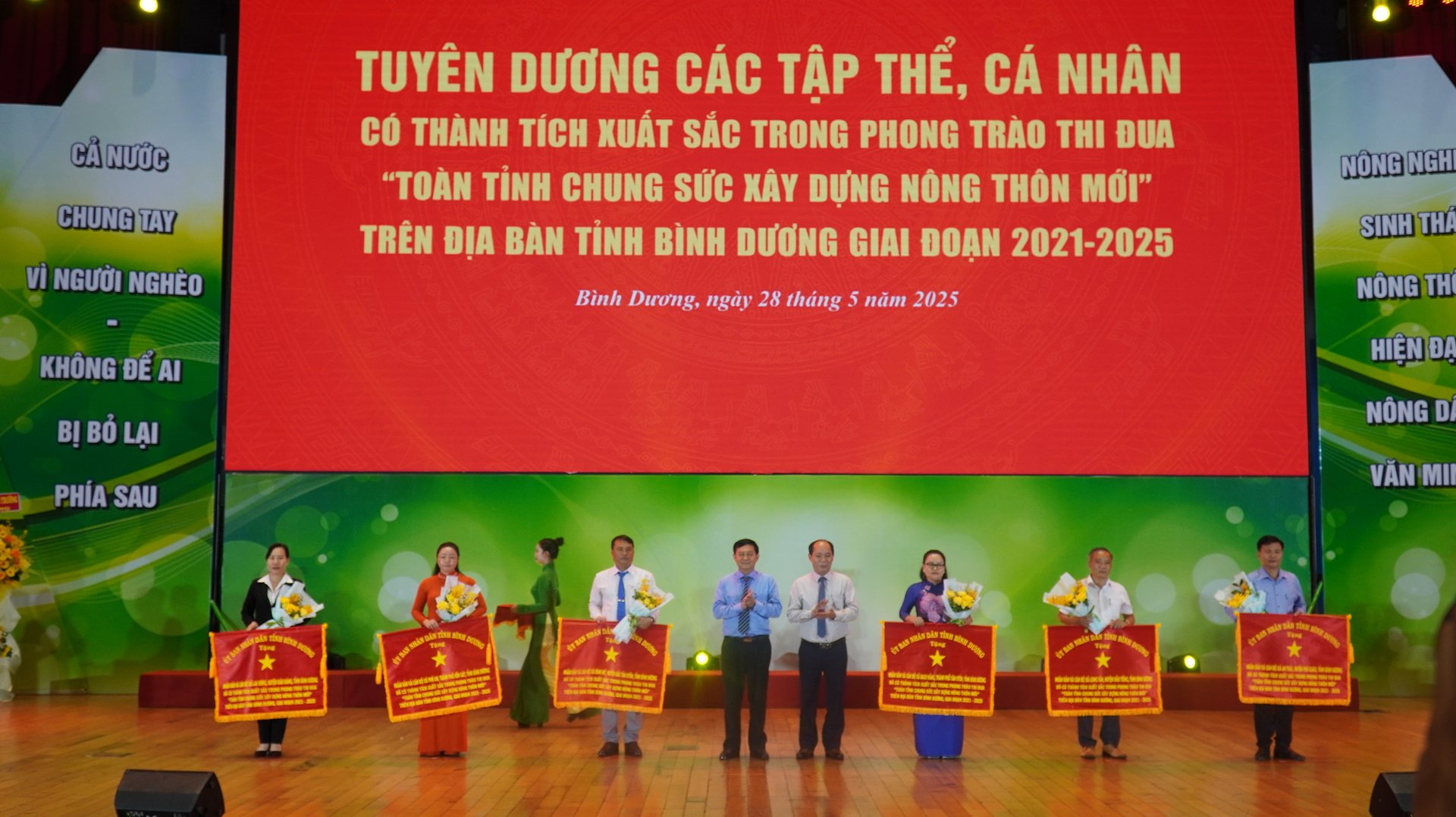 Lãnh đạo UBND tỉnh Bình Dương, cùng đại diện Bộ NN&MT trao Cờ thi đua cho các xã đạt chuẩn nông thôn mới nâng cao, ghi nhận những đóng góp nổi bật trong phong trào xây dựng nông thôn hiện đại, bền vững. Ảnh: Trần Phi. Lãnh đạo UBND tỉnh Bình Dương, cùng đại diện Bộ NN&MT trao Cờ thi đua cho các xã đạt chuẩn nông thôn mới nâng cao, ghi nhận những đóng góp nổi bật trong phong trào xây dựng nông thôn hiện đại, bền vững. Ảnh: Trần Phi.