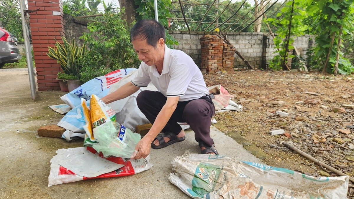 Ông Vui vừa gấp bao bì nylon, vừa vui vẻ trò chuyện: 'Mình nghèo, mình tiết kiệm là chuyện thường. Nhưng tiết kiệm mà đất sạch, cây khỏe thì lại càng nên làm'. Ảnh: Phạm Minh. Ông Vui vừa gấp bao bì nylon, vừa vui vẻ trò chuyện: 'Mình nghèo, mình tiết kiệm là chuyện thường. Nhưng tiết kiệm mà đất sạch, cây khỏe thì lại càng nên làm'. Ảnh: Phạm Minh.