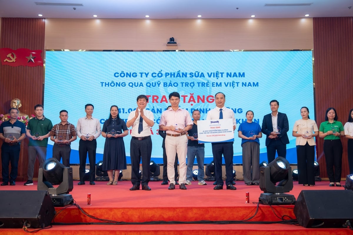 Ông Phạm Tuyên, Giám đốc chi nhánh Vinamilk Hà Nội (đứng giữa) trao bảng tượng trưng món quà 41.000 hộp sữa cho trẻ em Phú Thọ. Ảnh: Viên An.