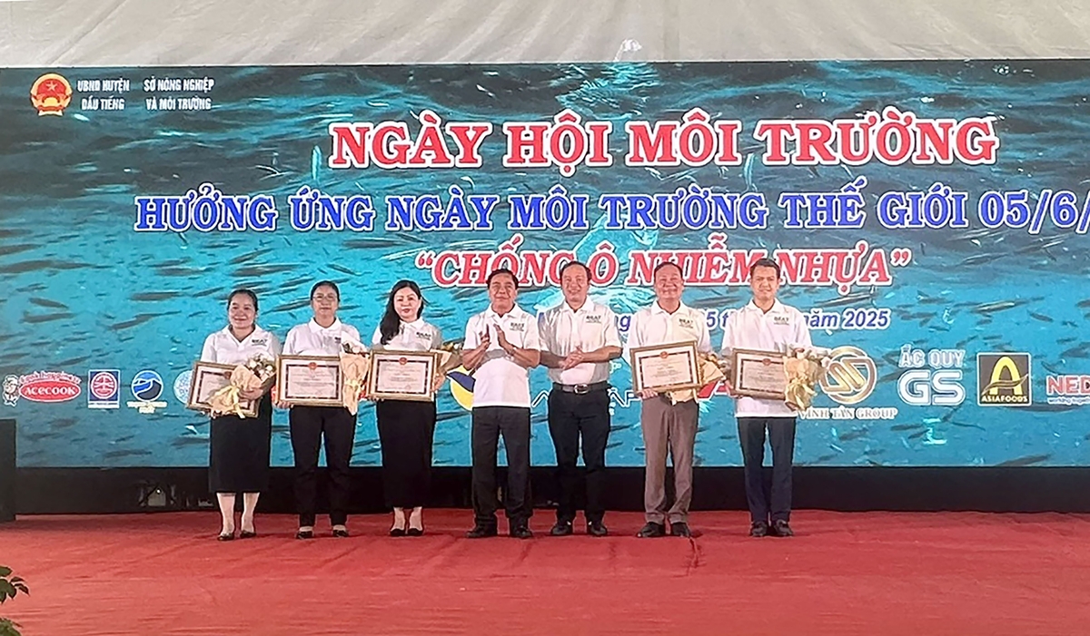 Lãnh đạo Sở NN&MT Bình Dương và UBND huyện Dầu Tiếng trao hoa và giấy khen cho các tập thể đã có thành tích xuất sắc trong đợt cao điểm thực hiện Tháng hành động vì môi trường. Ảnh: Tường Tú.