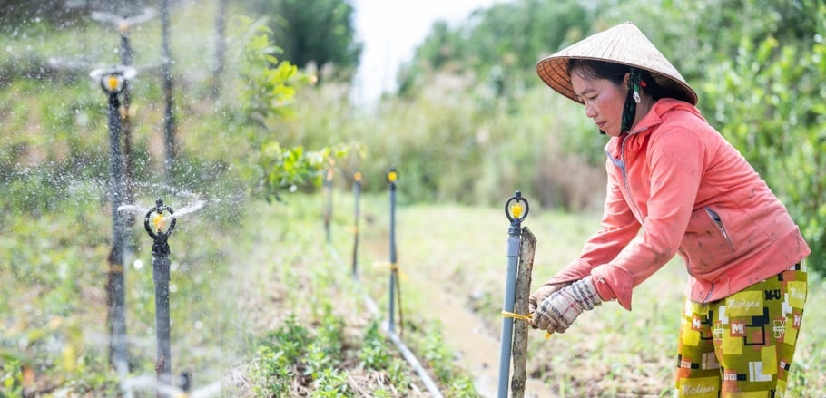 Chị Trần Thị Hiền, một phụ nữ thụ hưởng tại Cà Mau, đang vận hành hệ thống tưới tiêu tiết kiệm nước do dự án 'Nước là Sự sống' hỗ trợ. Ảnh: Nguyễn Đức Hiếu (UN Women).