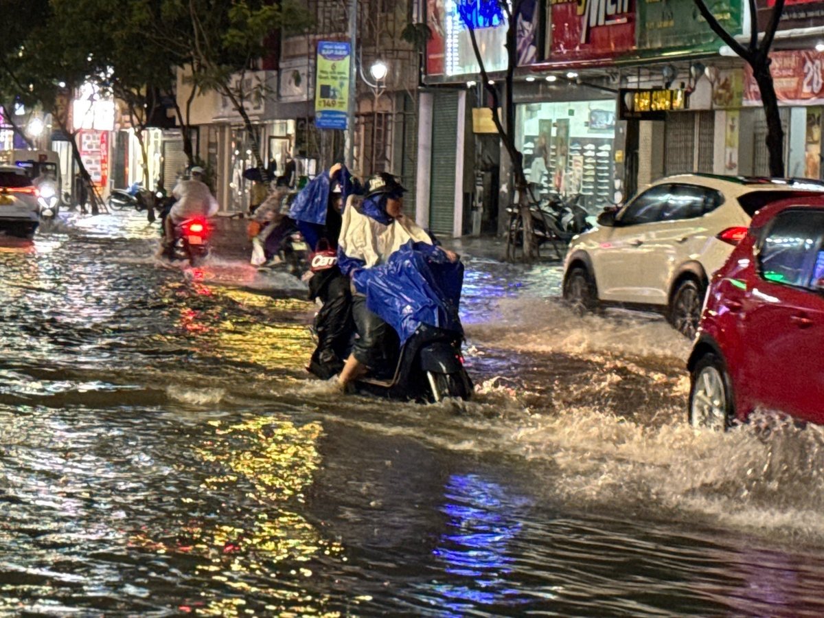 Người dân di chuyển khó khăn trong biển nước. Ảnh: Lan Anh Người dân di chuyển khó khăn trong biển nước. Ảnh: Lan Anh