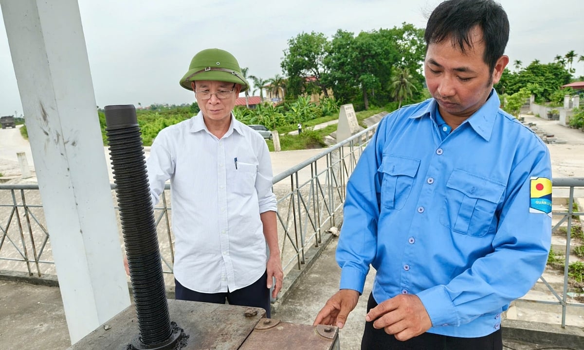 Anh Phạm Đắc Tươi (bên phải) kiểm tra cánh cống Gừng. Ảnh: Bảo Thắng. Anh Phạm Đắc Tươi (bên phải) kiểm tra cánh cống Gừng. Ảnh: Bảo Thắng.