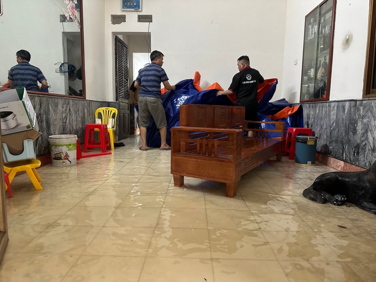 Người dân sống bên đường Quang Vinh di chuyển đồ đạc lên cao do lo sợ nước sẽ tiếp tục dâng lên.