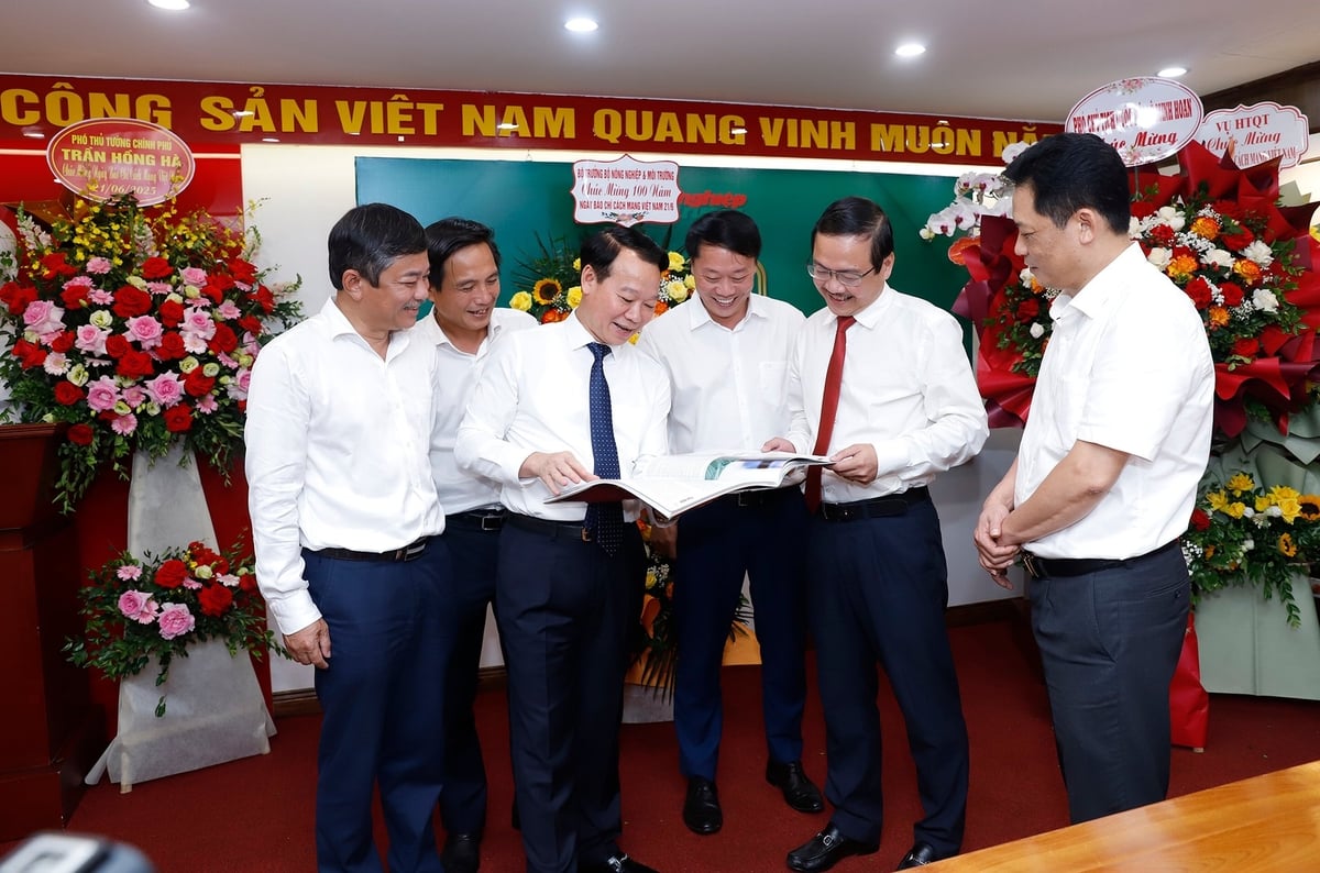 Bộ trưởng Bộ Nông nghiệp và Môi trường Đỗ Đức Duy xem số báo đặc biệt kỷ niệm 100 năm Báo chí cách mạng Việt Nam cùng Ban Biên tập Báo Nông nghiệp và Môi trường. Ảnh: Khương Trung.